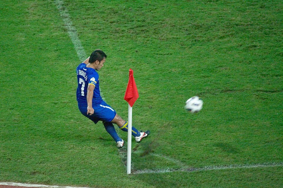 Jugador cobrando un tiro de esquina en un estadio argentino